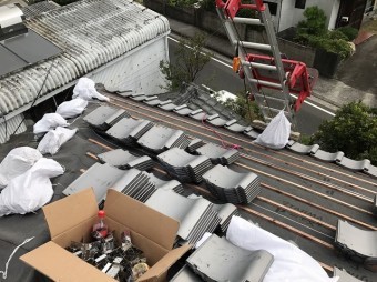 屋根に瓦を葺いていく様子