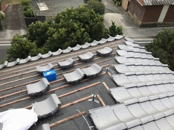 屋根に瓦を葺いていく様子