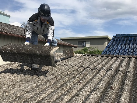 屋根材を運ぶ解体作業