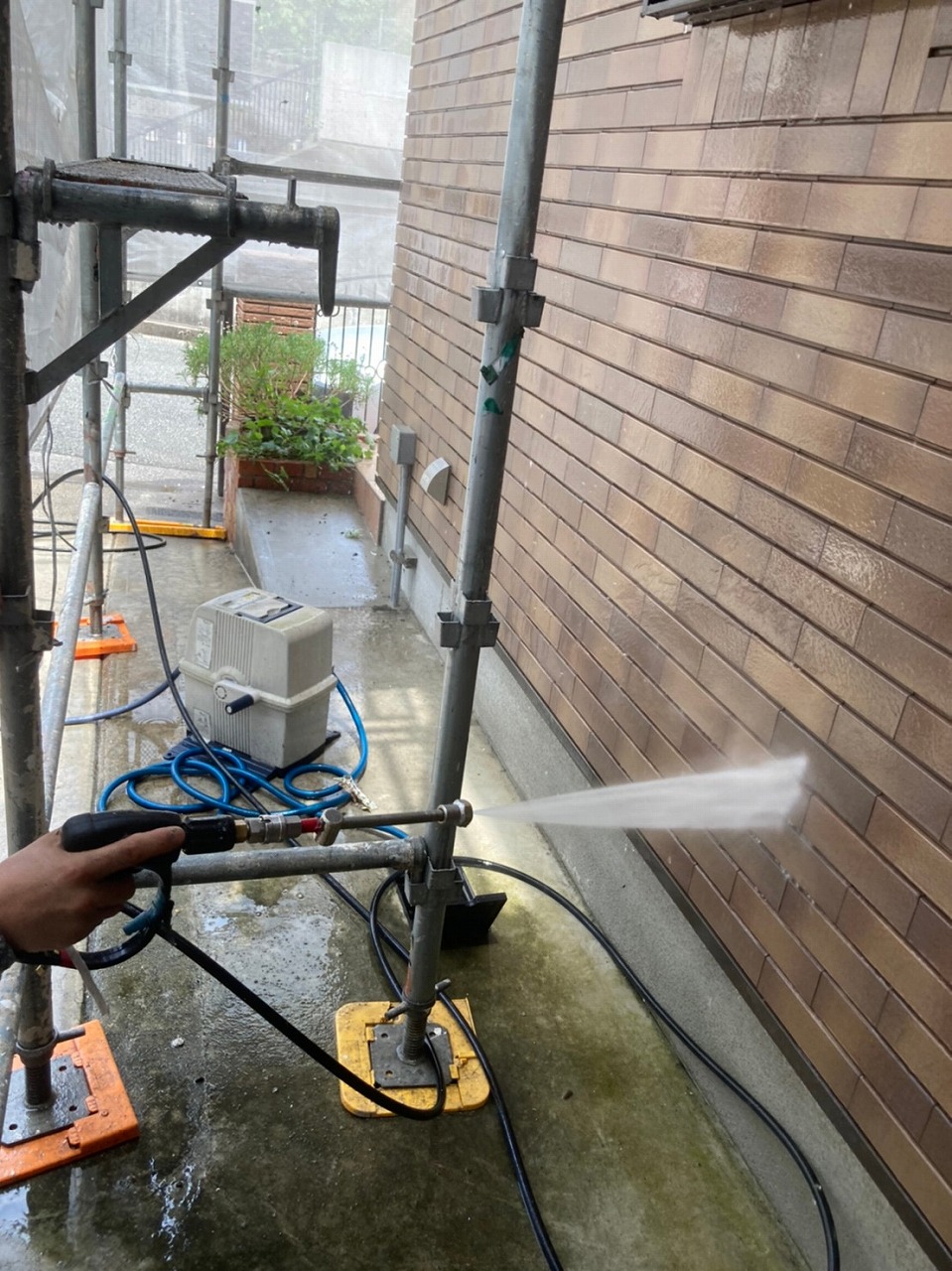 生駒市の屋根塗装現場で外壁の洗浄作業