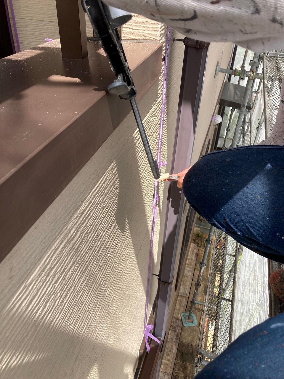 生駒市の屋根塗装現場で外壁のシール打ち